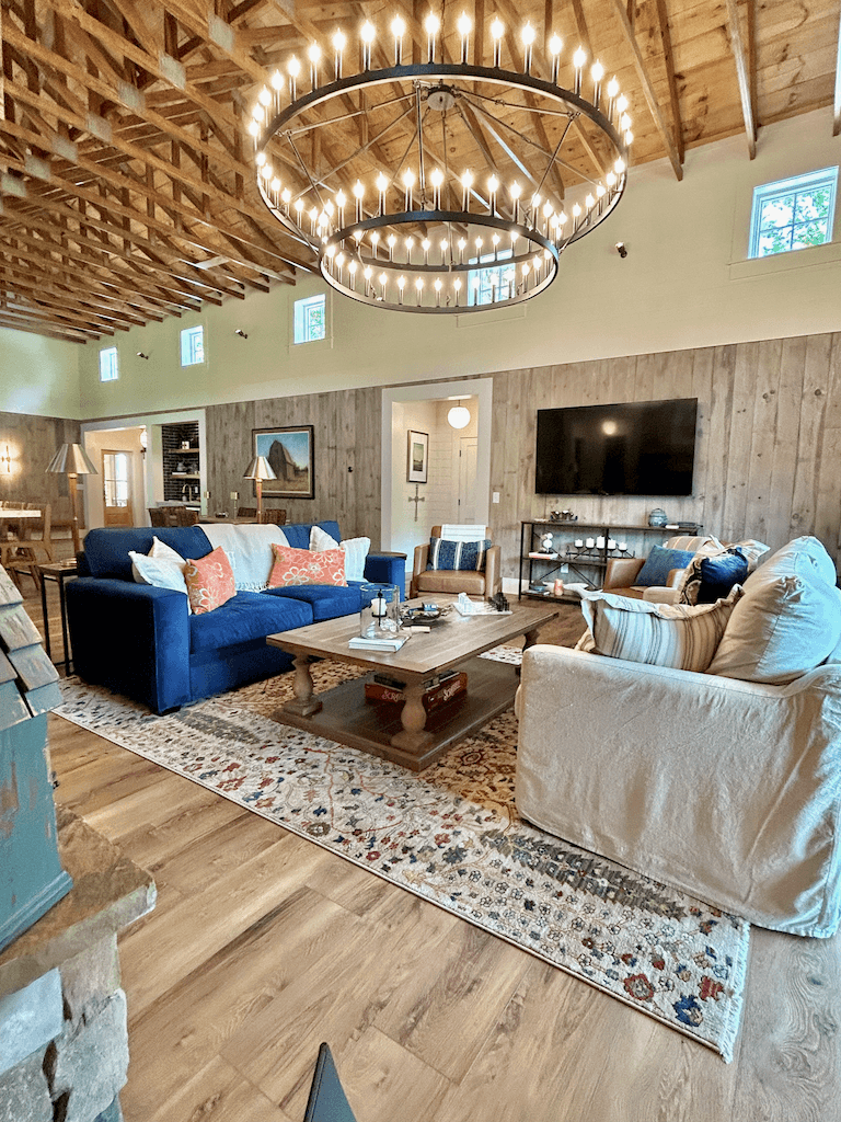The stone hearth in the great room — wood-stacked surround, comfortable seating arranged for conversation and the fire